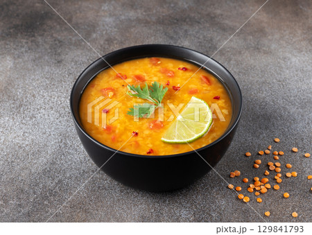 Red lentil soup with spices and fresh herbs on a gray background. Indian dal soup. 129841793