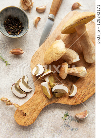 Chef preparing fresh mushrooms with garlic and pepper on cutting board Chef preparing fresh mushrooms with garlic and pepper on cutting board 129842171