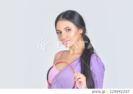Young hispanic female holding tennis racket with confident pose in casual 129842287