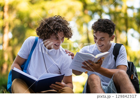 Teens learning lessons and looking involved while reading books 129842317