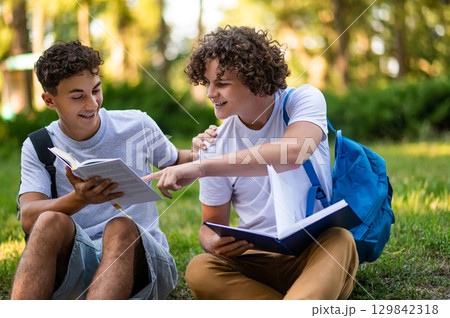 Teens learning lessons and looking involved while reading books 129842318