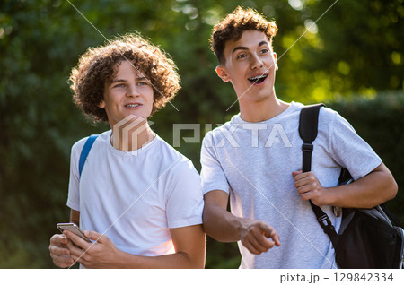 Two teens walking in the park and enjoying good weather 129842334