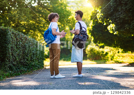 Two teens walking in the park and enjoying good weather Two teens walking in the park and enjoying good weather 129842336
