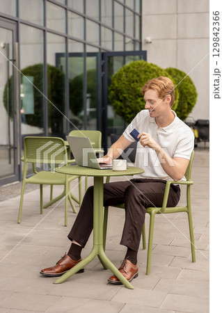 Digital nomad typing on computer validating payment using debit card Digital nomad typing on computer validating payment using debit card 129842366
