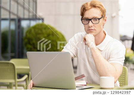 Ginger remote worker touching face thinking planning next steps Ginger remote worker touching face thinking planning next steps 129842397