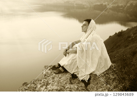 Young man sitting on the rock 129843689