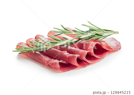 Slices of smoked bresaola isolated on white background. Slices of smoked bresaola isolated on white background. 129845215