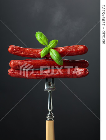 Thin grilled sausages with basil. Thin grilled sausages with basil. 129845371