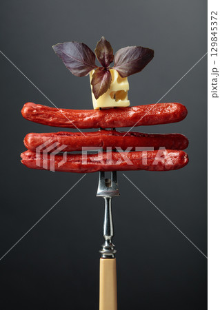 Grilled sausages with cheese and basil. 129845372
