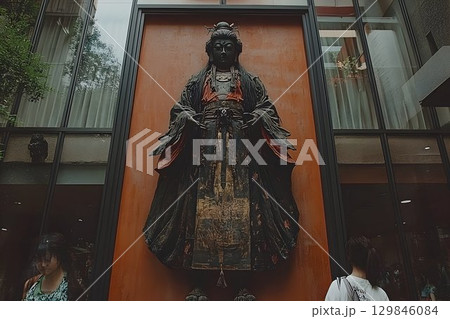 Elegant sculpture of bodhisattva exhibited on a facade in a modern building 129846084