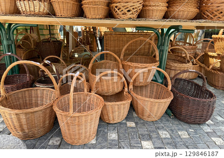 Numerous wicker baskets of varying shapes and sizes are neatly arranged on a market stall, showcasing traditional craftsmanship and offering a variety of storage solutions 129846187