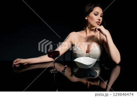 Woman enjoys spaghetti in a studio setting with elegant lighting Woman enjoys spaghetti in a studio setting with elegant lighting 129846474
