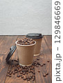 Paper cup with coffee beans. Takeaway coffee concept. Modern lifestyle. Close-up 129846669