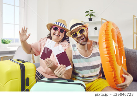 Happy funny family couple have bought tickets and are ready for their summer vacation 129846725