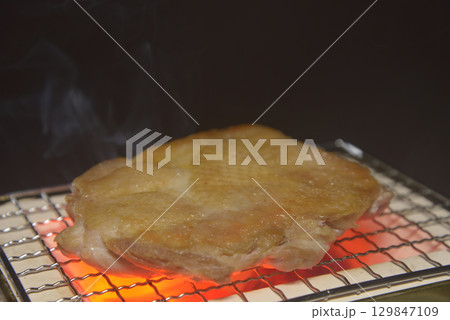煙りの立ち昇る七輪で鶏モモ肉を焼く 煙りの立ち昇る七輪で鶏モモ肉を焼く 129847109