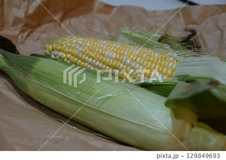 実がぎっしりつまった皮を剥いたとうもろこし 129849693