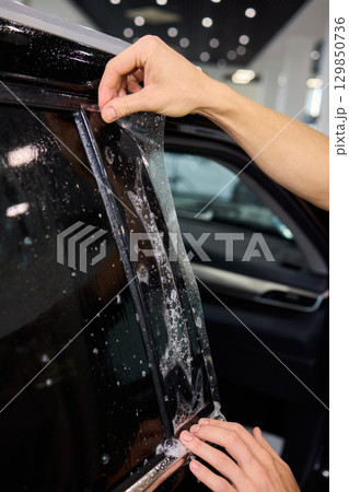 Applying a Protective Film on the Surface of Your Car for Enhanced Durability and Shine 129850736