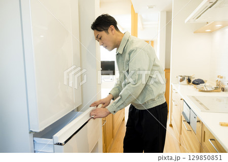 冷蔵庫設置作業する作業服の男性 冷蔵庫設置作業する作業服の男性 129850851