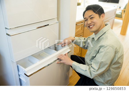 冷蔵庫設置作業する作業服の男性 129850853