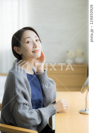 肌荒れを気にするニットの女性 129850926