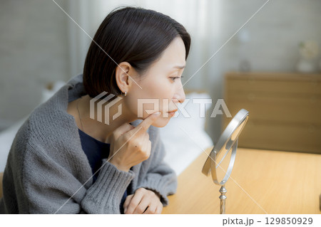 肌荒れを気にするニットの女性 129850929