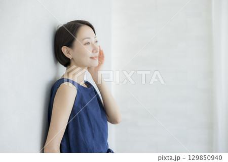 壁にもたれかかる女性 129850940