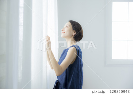 カーテンを開ける女性 カーテンを開ける女性 129850948
