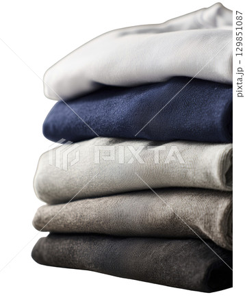 Stack of folded clothes in neutral tones conveys sense of neatness and serenity, perfect for minimalist lifestyle designs 129851087