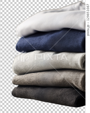 Stack of folded clothes in neutral tones conveys sense of neatness and serenity, perfect for minimalist lifestyle designs 129851087