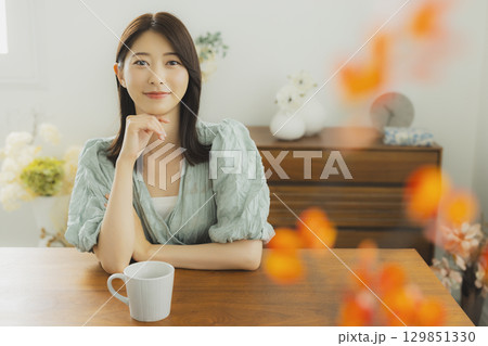 部屋でコーヒーを飲む若い　女性 　 129851330