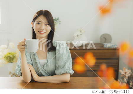 部屋でコーヒーを飲む若い　女性 　 129851331