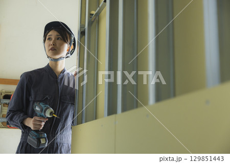 建築現場で働く若い女性作業員 建築現場で働く若い女性作業員 129851443