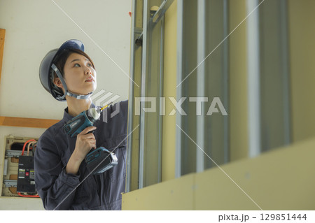 建築現場で働く若い女性作業員 建築現場で働く若い女性作業員 129851444