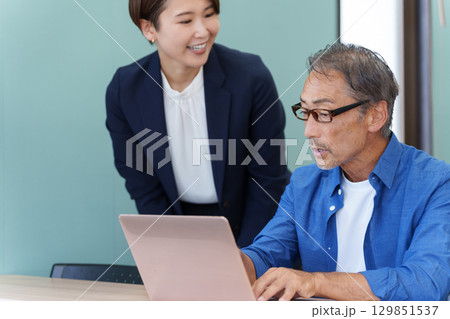 パソコン教室に通うシニアと教える講師 パソコン教室に通うシニアと教える講師 129851537