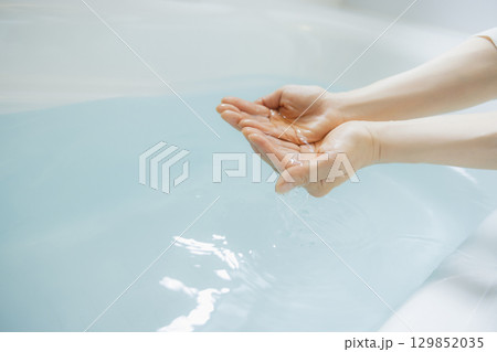 お湯を掬う女性の手　 129852035