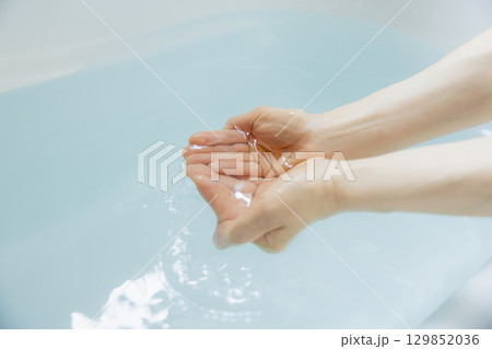 お湯を掬う女性の手　 129852036