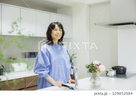 キッチンで花瓶を持つ女性 キッチンで花瓶を持つ女性 129852084