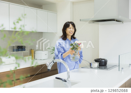 キッチンで花瓶を持つ女性　 129852088