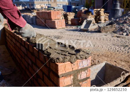 Bricklayer Hard at Work Ongoing Construction of a Residential Building Structure 129852250