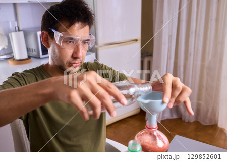 A Young Scientist Conducting a Home Experiment with Proper Safety Gear for Protection A Young Scientist Conducting a Home Experiment with Proper Safety Gear for Protection 129852601