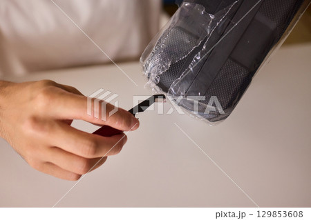 Unboxing a New Electronic Device with Great Care and Attention to Detail and Excitement Unboxing a New Electronic Device with Great Care and Attention to Detail and Excitement 129853608