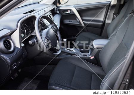 Closeup of a modern car steering wheel with control buttons for technology and convenience 129853624