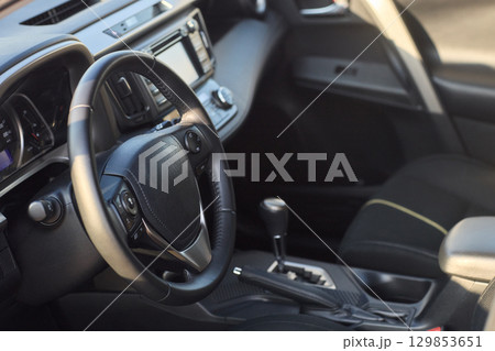 Closeup of a modern car steering wheel with control buttons for technology and convenience Closeup of a modern car steering wheel with control buttons for technology and convenience 129853651