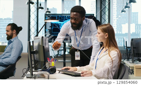 Startup office manager congratulates young girl after developing artificial intelligence models for business analytics. Team leader doing fist bump with female engineers pleased by work done, camera A Startup office manager congratulates young girl after developing artificial intelligence models for business analytics. Team leader doing fist bump with female engineers pleased by work done, camera A 129854060