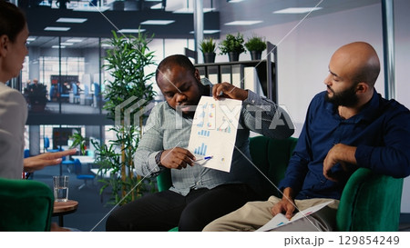 Strategic planning session among empowered business people focused on goal oriented metrics and partnership opportunities. Working on a success story in multicultural environment. Camera A. 129854249
