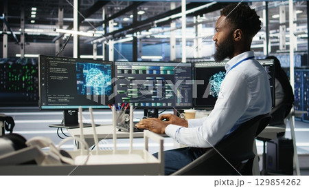 Server hub admin using AI neural network node tree program to optimize system health. Data center IT professional analyzing equipment issues using deep learning AI visualization, camera A 129854262