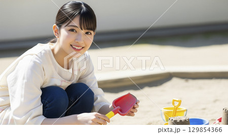 保育士と園児たちがお砂場で遊ぶ 保育士と園児たちがお砂場で遊ぶ 129854366