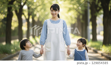 保育士と園児たちが仲良くお散歩している 129854385