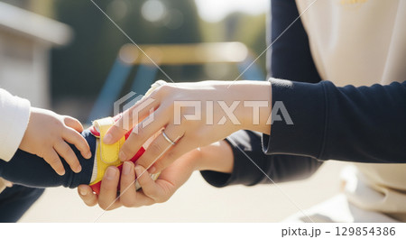 保育士が園児の靴を履かせる　お手伝い 129854386