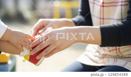 保育士が園児の靴を履かせる　お手伝い 129854389